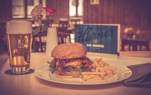a sandwich and french fries on a table with a glass of beer at DAS HÜRNER in Ansbach