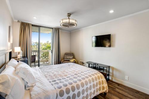 um quarto com uma cama grande e uma varanda em Modern condo with access to pool & hot tub in great location em Oceanside