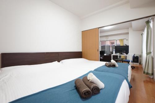 een slaapkamer met een bed met handdoeken erop bij 豊水すすきの駅から徒歩数分 IK Minami 6 Jo Residence 101 IK南6条レジデンス in Sapporo