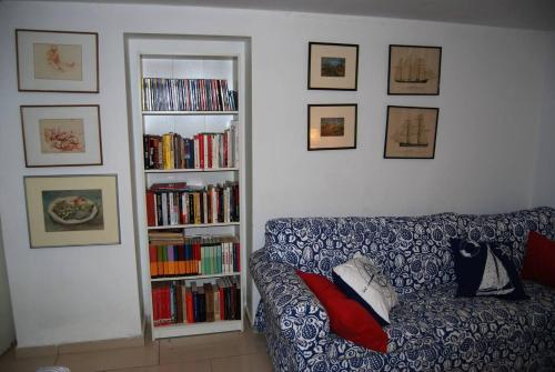 a living room with a couch and a book shelf with books at Rustic House Miketa - Family Summertime in Lukoran