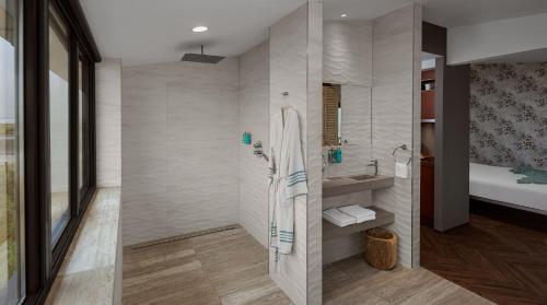 a bathroom with a shower and a sink at Beachhouse Hotel in Zandvoort