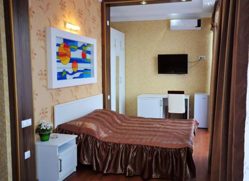a bedroom with a bed and a tv on the wall at Hotel Albatros in Ureki