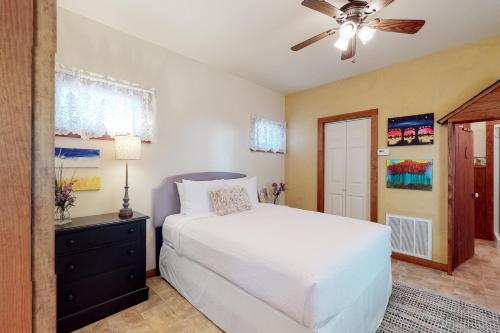 a bedroom with a white bed and a ceiling fan at Sip & Stay in Fredericksburg