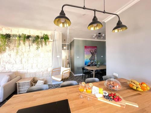 a living room with a wooden table and a dining room at APTER-Boutique Apartment אפטר - דירת בוטיק בכנרת in Tiberias