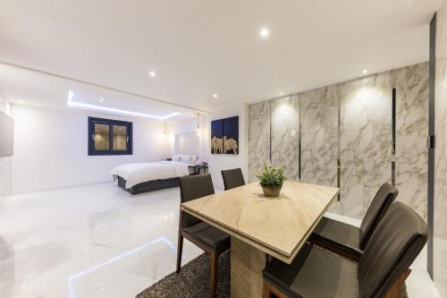 a room with a dining table and a bedroom at Seosan Aria Hotel in Seosan