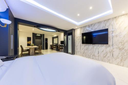 a bedroom with a large bed with a tv on a wall at Seosan Aria Hotel in Seosan
