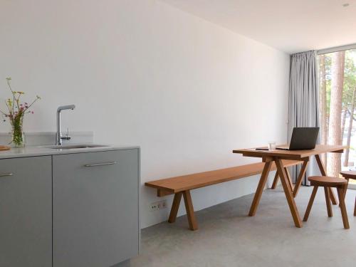 una cocina con un banco y un ordenador portátil sobre una mesa en Apartamentos Camping Coroso en Ribeira