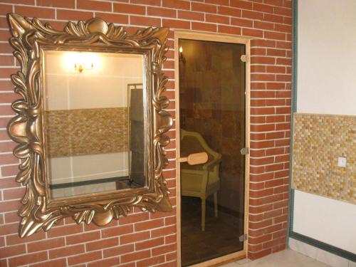 un espejo en una pared de ladrillo junto a una puerta en Hotel Armales, en Stakčín