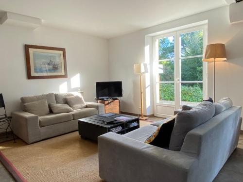 un salon avec un canapé et une télévision dans l'établissement REF 001 - Belle maison avec jardin pour six personnes KERNERS ARZON, à Arzon