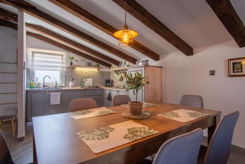 a kitchen and dining room with a wooden table and chairs at Opg Pelejš in Pag