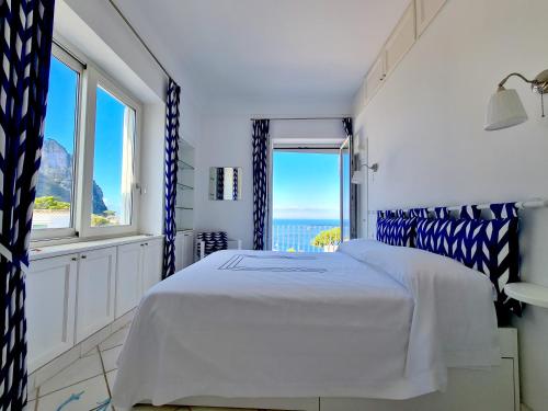 a bedroom with a bed with a view of the ocean at Blu Acquaviva in Capri