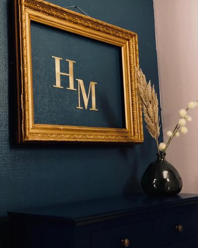 a picture on a wall with a vase on a dresser at Hotel Le Midi Clermont-Cournon in Cournon-dʼAuvergne