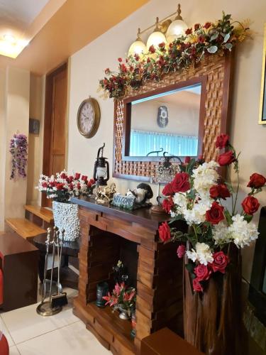 a living room with a fireplace and a mirror at Dahilayan Comfy Cabin in Manolo Fortich