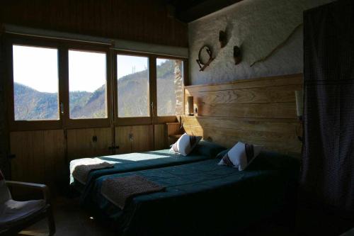 La cabanya de Can Planes un petit gran espai في Rocabruna: سريرين في غرفة بها نافذتين