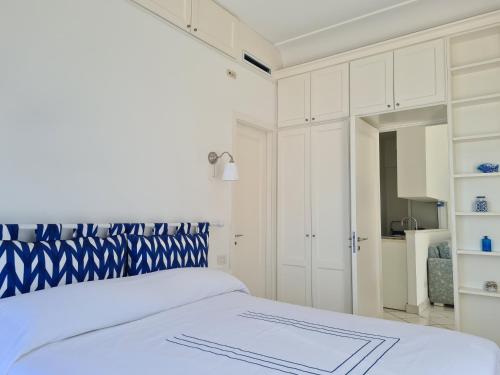 a white bedroom with a blue and white bed at Blu Acquaviva in Capri