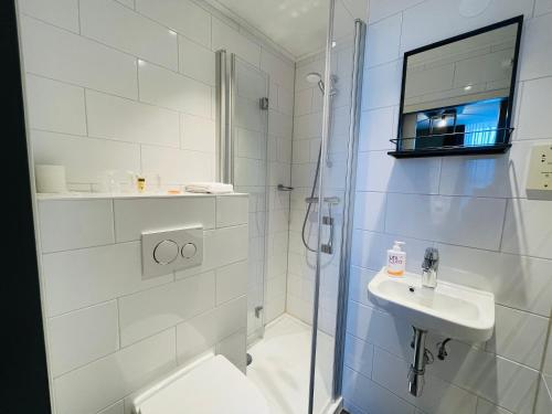 a bathroom with a shower and a toilet and a sink at Prinsengracht Hotel in Amsterdam