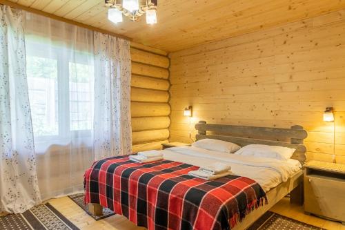 a bedroom with a bed in a wooden cabin at Konopka Forest Home & SPA in Bukovel