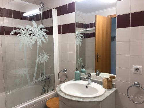 a bathroom with a sink and a tub and a mirror at Ericeira Surf and Sun in Ericeira