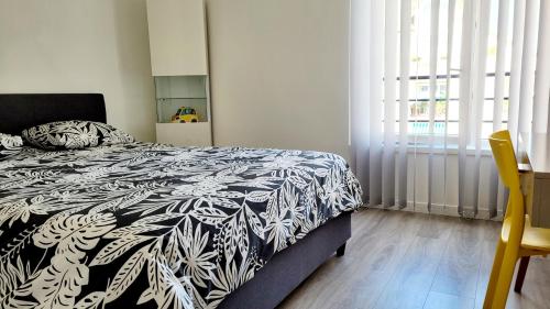 une chambre avec un lit avec une couette noire et blanche dans l'établissement Beau Regard, à Besançon