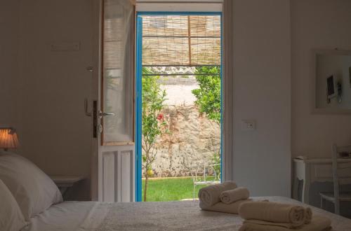 a bedroom with a bed and a door to a yard at La Casa del Limoneto in Favignana
