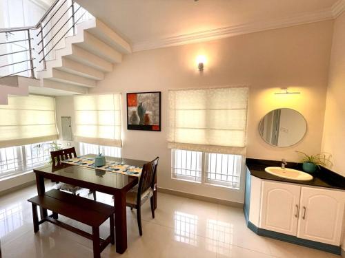 ein Esszimmer mit einem Tisch und einem Waschbecken in der Unterkunft The Oval House - Approved by Kerala Tourism in Kochi