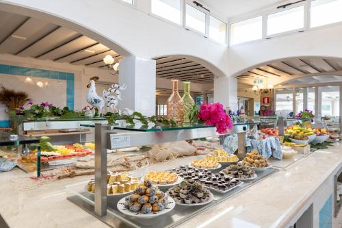 una línea de buffet con muchos tipos diferentes de comida en Tirreno Resort, en Cala Liberotto