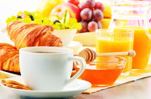 a breakfast table with a cup of coffee and croissants at Berggasthof Banzer Wald in Bad Staffelstein
