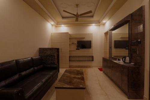 a living room with a leather couch and a television at Shri Tirupati Residency in Nilmatha