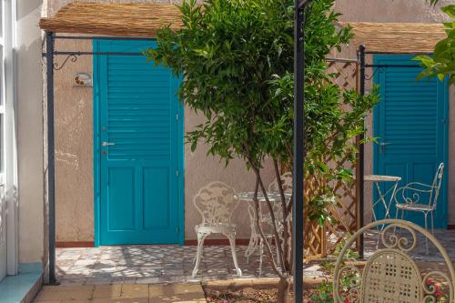 a building with blue doors and a table and chairs at La Casa del Limoneto in Favignana