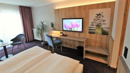 a hotel room with a desk and a television at Hotel Thormählen in Lübeck