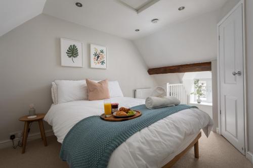 une chambre avec un lit avec un plateau de nourriture dessus dans l'établissement The Cottage, à Cirencester