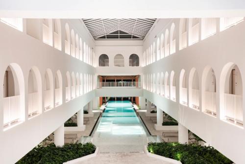 a corridor of a building with a swimming pool at Away Bangkok Riverside Kene in Bangkok