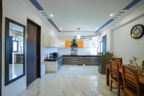 a kitchen with a refrigerator and a table and chairs at Lime Tree Service Apartment - Near Artemis Hospital ,Gurgaon in Gurgaon