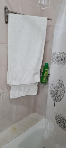 ein Badezimmer mit einem weißen Handtuch und einem Sonnenschirm in der Unterkunft Apartamentos Tesón Ribadeo in Ribadeo