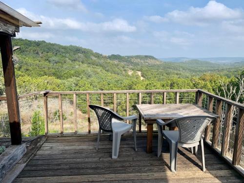 a table and chairs on a wooden deck with a view at La Vista in Canyon Lake