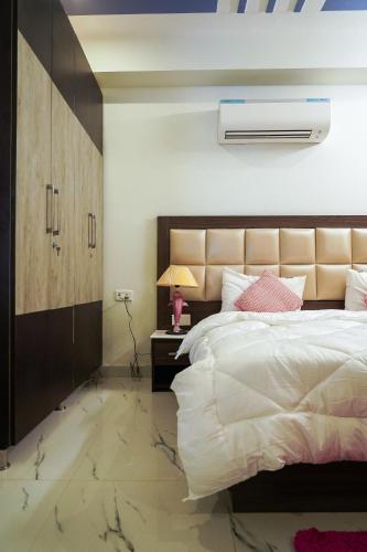 a bedroom with a large white bed and a lamp at Lime Tree Service Apartment - Near Artemis Hospital ,Gurgaon in Gurgaon