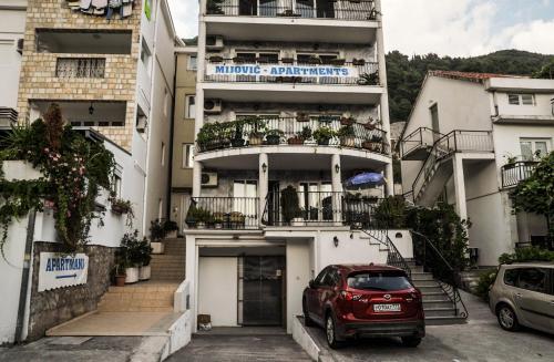 a red car parked in front of a building at Mijovic Apartments in Budva