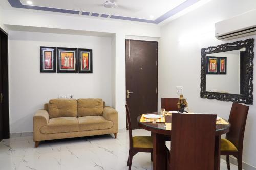 a living room with a couch and a table and a mirror at Lime Tree Service Apartment - Near Artemis Hospital ,Gurgaon in Gurgaon