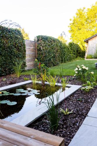 a garden with a pond with lilies and plants at 110qm Countryside Loft in Neufahrn in Niederbayern