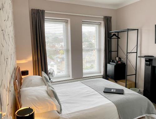 a bedroom with a bed with a laptop on it at The Earlsdale Bed and Breakfast in Ilfracombe