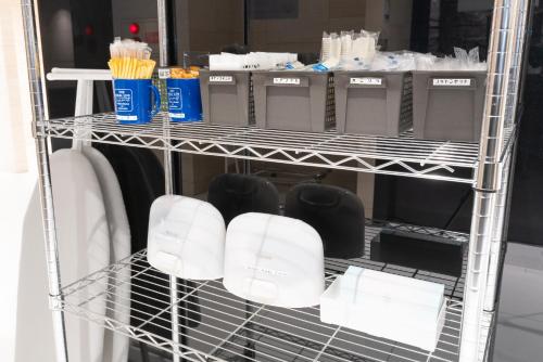 a shelf in a closet filled with white objects at ibis Budget Osaka Umeda in Osaka