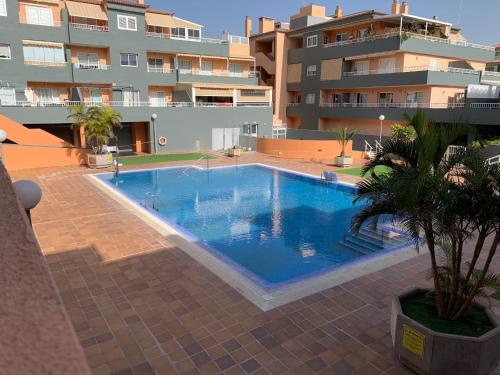 una piscina di fronte a un edificio di La Brisa del Mar - Piscina y Terraza a Puertito de Güímar