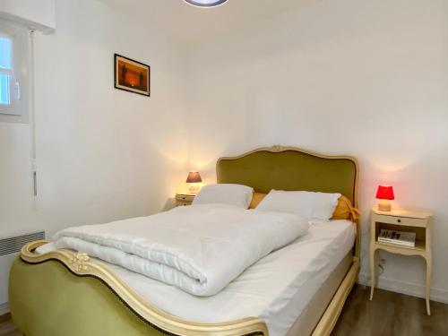 - une chambre avec un lit avec des draps blancs et 2 lampes dans l'établissement REF 011 - Appartement 2 pièces à deux pas du Port du Crouesty, à Arzon