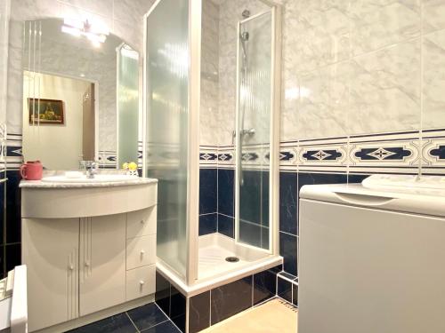une salle de bain blanche avec une douche et un lavabo dans l'établissement REF 011 - Appartement 2 pièces à deux pas du Port du Crouesty, à Arzon