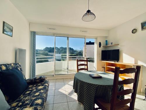 un salon avec une table et un canapé dans l'établissement REF 011 - Appartement 2 pièces à deux pas du Port du Crouesty, à Arzon