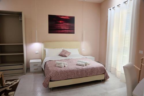 a bedroom with a bed with two stuffed animals on it at La Nuit in Agrigento
