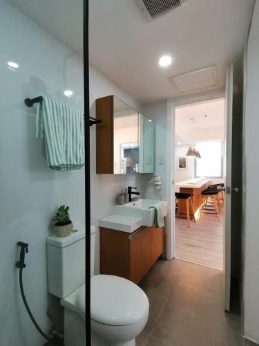 a bathroom with a toilet and a sink and a mirror at Holiday Escape Philippines in Manila