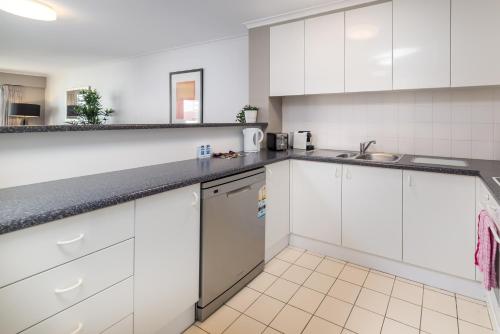 a kitchen with white cabinets and a dishwasher at 2BR 2Bath L8 Executive Apartment, in City Centre in Canberra