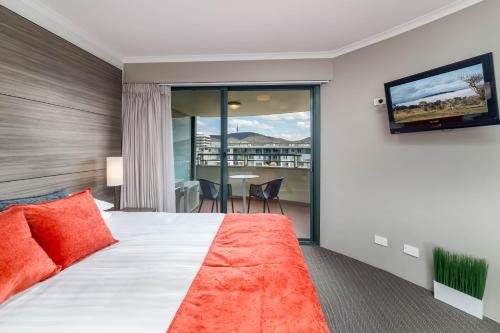 um quarto de hotel com uma cama e uma televisão de ecrã plano em 2BR 2Bath L8 Executive Apartment, in City Centre em Camberra