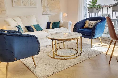 ein Wohnzimmer mit einem Sofa, einem Tisch und Stühlen in der Unterkunft Appartement style architecte proche de la plage in Cannes